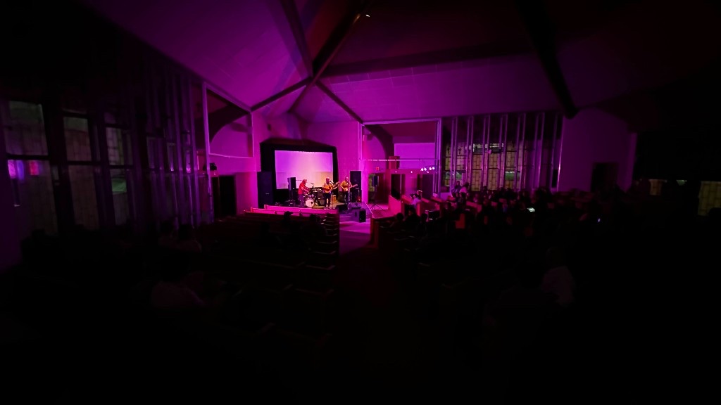 Saints and Liars on stage in the Performing Arts Center, with the room washed in color.