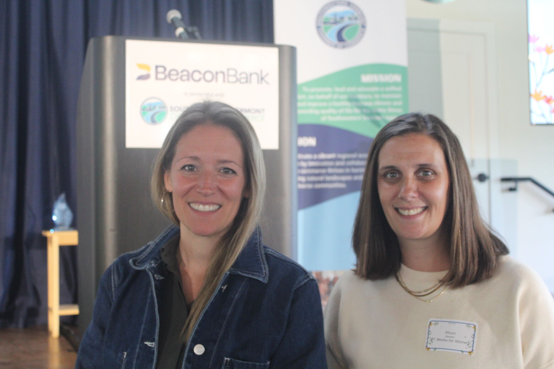 Keynote speakers Emily Bush and Rhoni Basden at the podium, Women in Leadership Luncheon 2026.