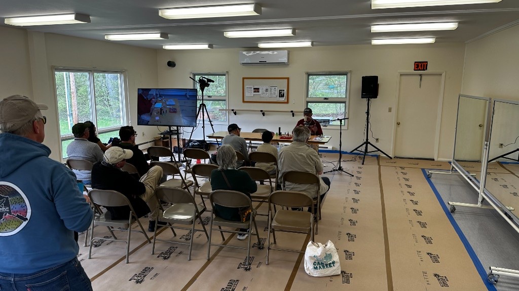 A fly-tying demonstration, with a camera feeding a monitor so the back row could see the vise.