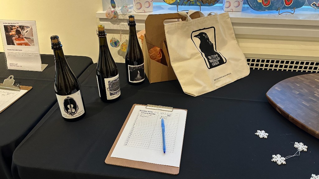 Silent auction lots on a side table, with a bid sheet and a pen.
