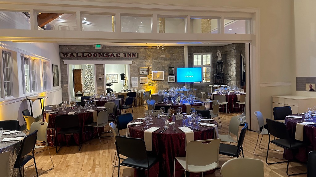 Tables set toward the Walloomsac Inn sign, with a screen and a Christmas tree beyond.
