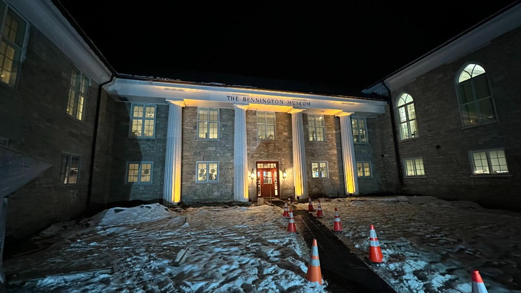 The Bennington Museum entrance at night, columns washed with warm uplight.