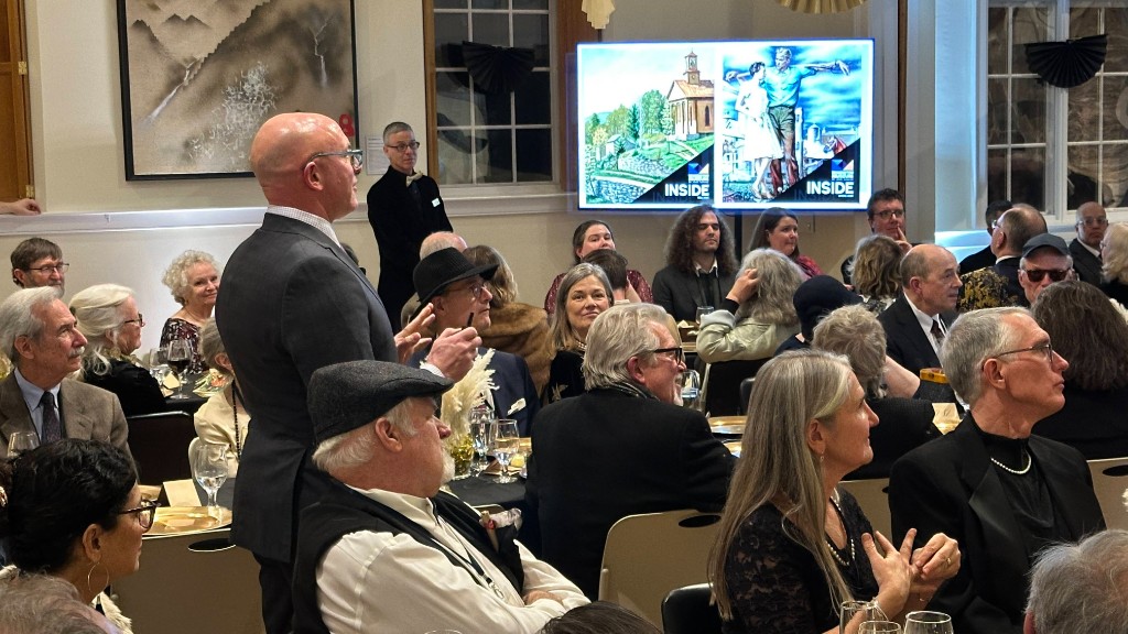 Guests watching a split screen of exhibition art during the Vermont Vice Gala.
