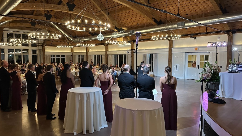 Guests watching a dance in Lincoln Hall, with the mirror ball and chandeliers overhead.