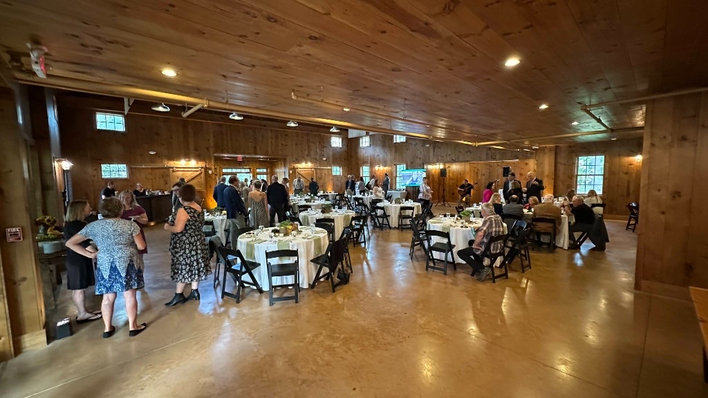 The Celebration Barn set for the Harvest Moon Gala, screen and guitar at the far wall.